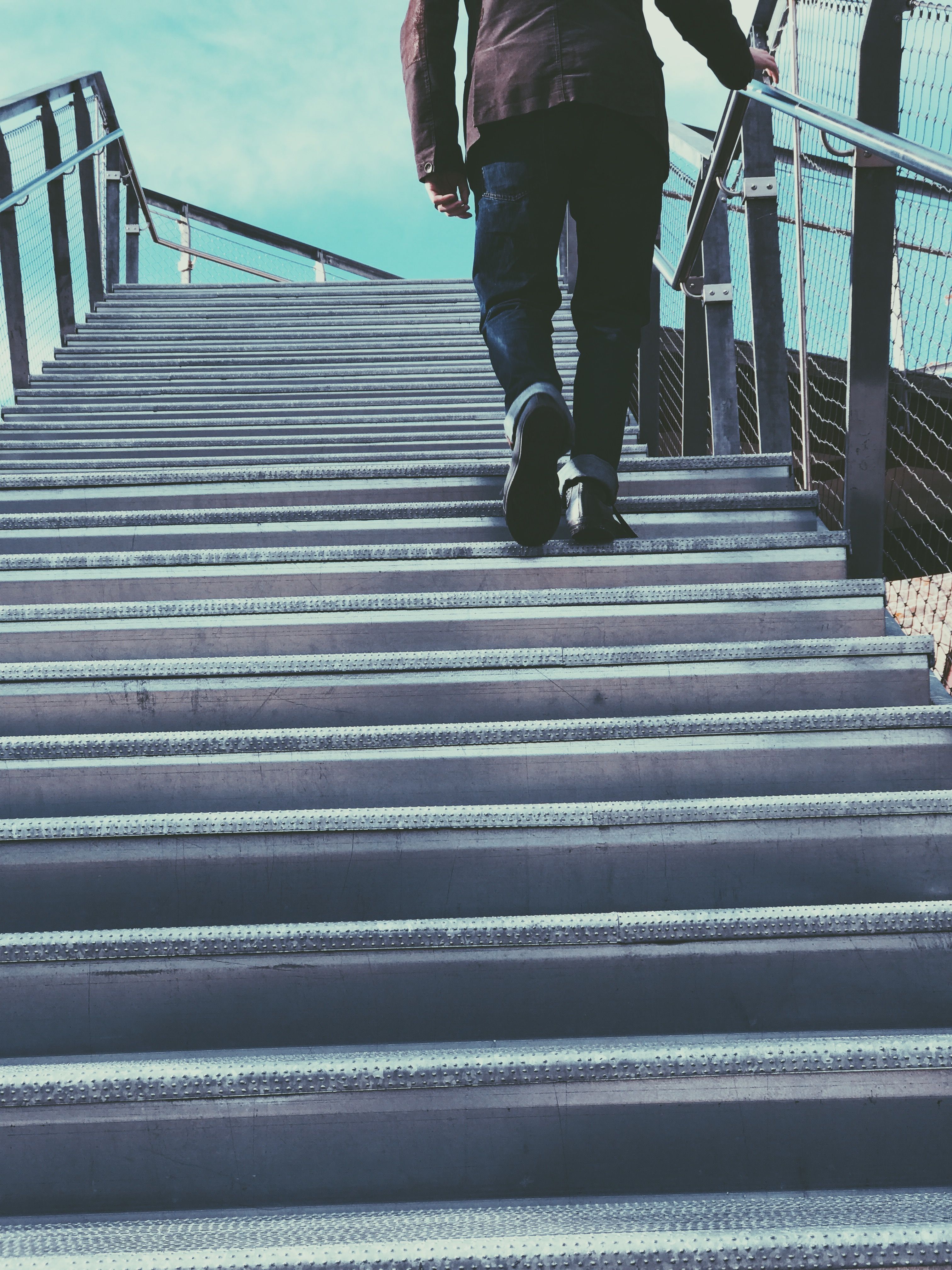 Personne montant un escalier, symbolisant une progression par paliers